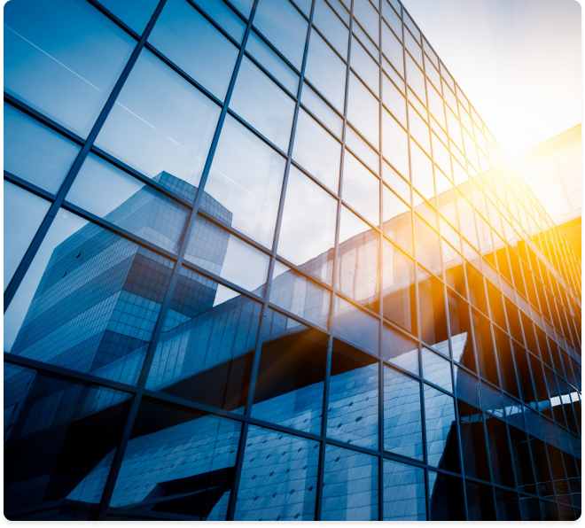 Modern building with reflective windows and sunlight, showcasing architectural design.