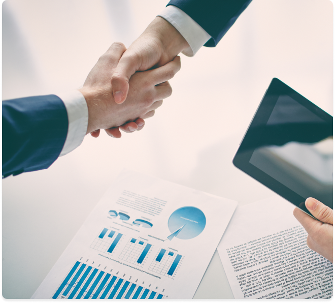 Two businessmen shaking hands over a document, depicting a professional agreement.