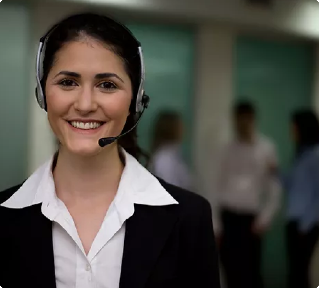 Professional woman wearing a headset, smiling, in a customer service setting.