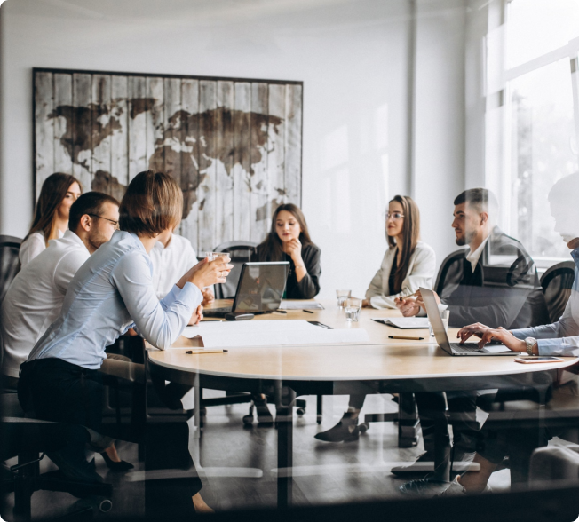 Young professionals in a meeting behind glass in a modern conference room.